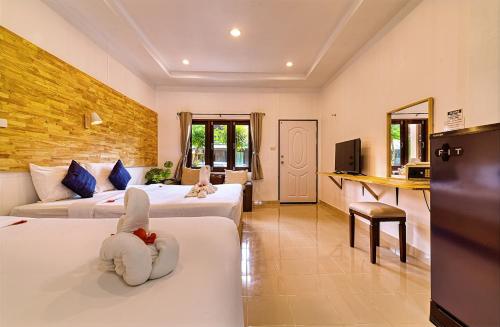 ein Hotelzimmer mit zwei Betten und einem Fernseher in der Unterkunft The Bulin Residence in Lamai