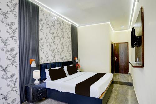a bedroom with a bed with a black and white comforter at Hotel O Raj Ambessy in Rāmpura