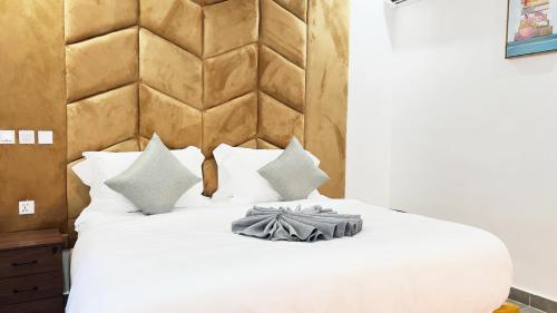 a bedroom with a white bed with a wooden headboard at GPR Suites & Apartments in Aso