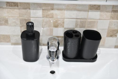 a sink with two cups and a faucet on it at Apartman LUCIA 2 in Ðakovo