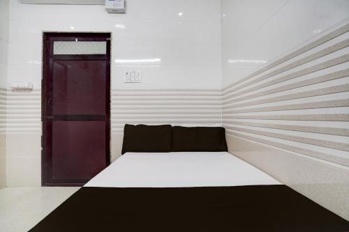 a bed in a room with a red door at SPOT ON Radhakund Guest House in Rādha Kund