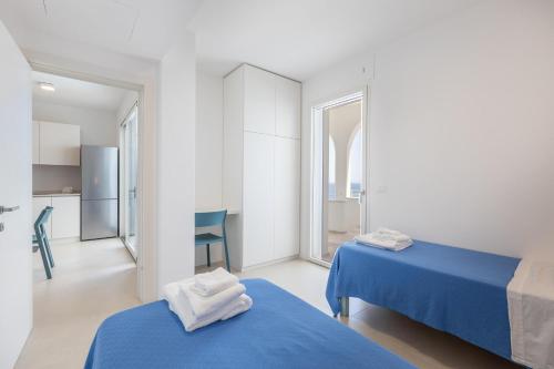 una camera d'albergo con due letti e una cucina di Marinaia Archi a Marittima