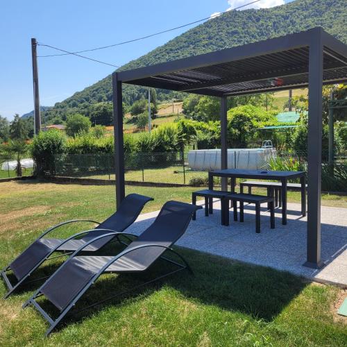 a gazebo with chairs and a table and a picnic table at Garden Relais Mountain Lake Iseo Hospitality in Solto Collina
