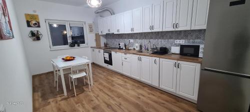 a kitchen with white cabinets and a table in it at Luma Haven in Şelimbăr