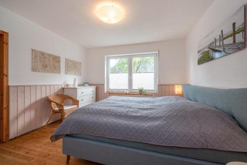 a bedroom with a bed and a desk and a window at Huus Strandgut in Fehmarn