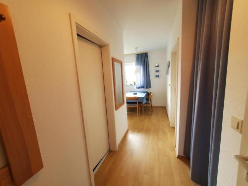 a hallway with a door to a room with a table at Sundby in Lemkenhafen auf Fehmarn