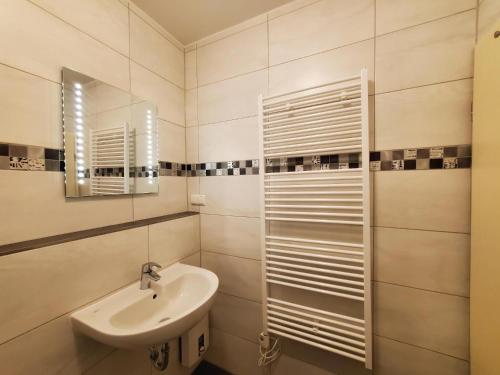 une salle de bain avec un lavabo et un miroir dans l'établissement Sundby, à Lemkenhafen auf Fehmarn