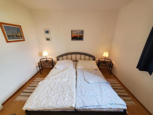 Cette chambre dispose de lits jumeaux et de deux lampes. dans l'établissement Sundby, à Lemkenhafen auf Fehmarn