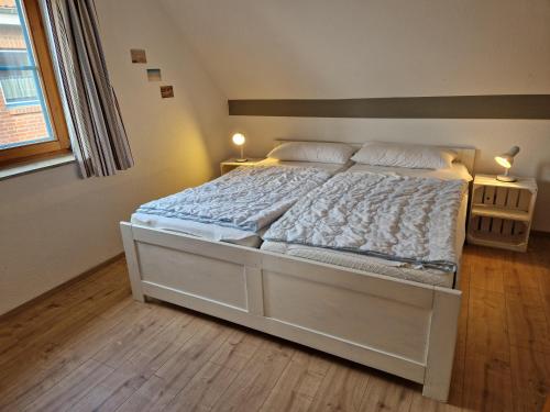 - un grand lit blanc dans une chambre avec deux lampes dans l'établissement Kajüte 4, à Lemkenhafen auf Fehmarn