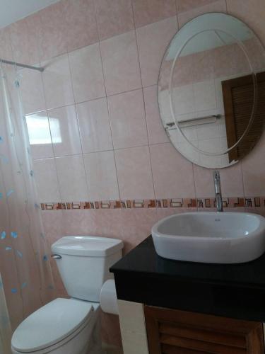 a bathroom with a toilet and a sink and a mirror at Pintree Pattaya in Pattaya South