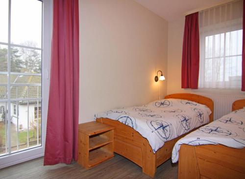 ein Schlafzimmer mit zwei Einzelbetten und einem Fenster in der Unterkunft Orth A6 in Orth