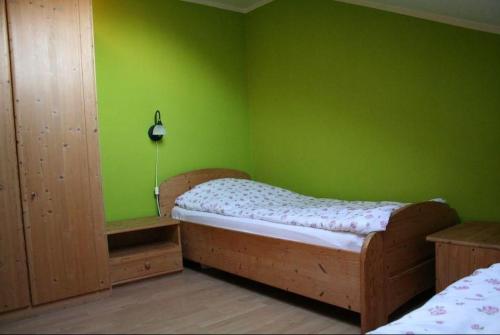 a bedroom with a bed and a green wall at Orther Hafenblick in Orth