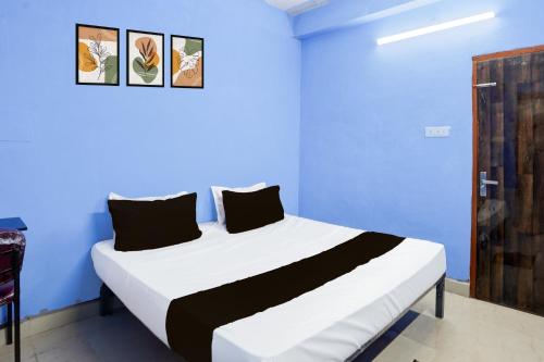 a bed in a blue room with a blue wall at HOTEL O PRAGYA 6 in Raipur
