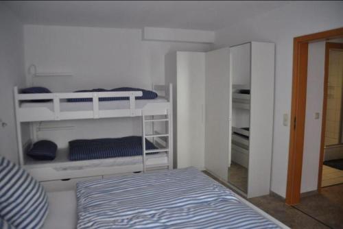 une chambre blanche avec deux lits superposés et un lit dans l'établissement Orth C24, à Orth