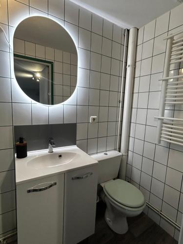 a bathroom with a sink and a toilet and a mirror at Centre ville - Berthelot in Chamalières