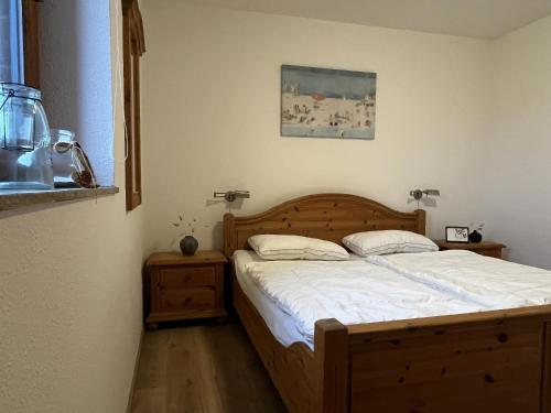 une chambre avec un lit avec une tête de lit en bois dans l'établissement L36EG links, à Lemkenhafen auf Fehmarn