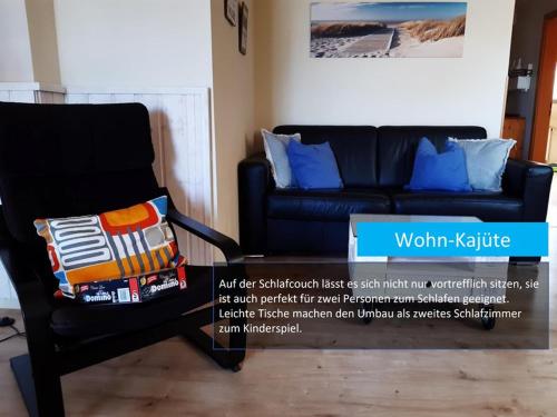 a black chair with a pillow on it in a living room at Hafenblick in Orth