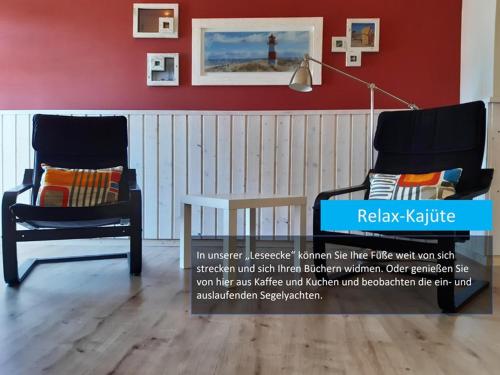 a room with two chairs and a red wall at Hafenblick in Orth