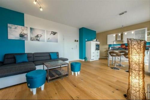 a living room with a couch and blue walls at Surf and Chill in Orth