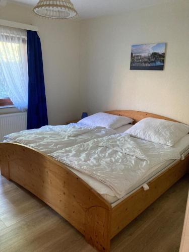 a large wooden bed in a bedroom with a window at Orth Poststraße 8 EG in Orth