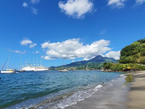 a view of a beach with boats in the water at La Maison Jaune - Swimming pool & beach access 50 m away in Saint-Pierre