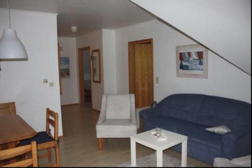 a living room with a blue couch and a table at Lichtblick in Petersdorf auf Fehmarn