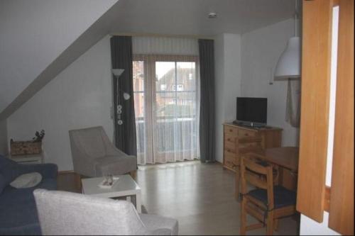 a living room with a couch and a table and a television at Lichtblick in Petersdorf auf Fehmarn