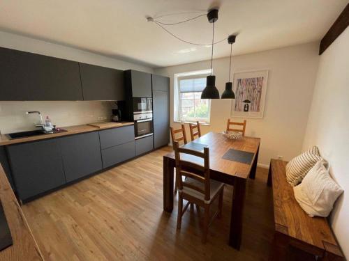 una cucina e una sala da pranzo con tavolo e sedie di Welcome a Petersdorf auf Fehmarn