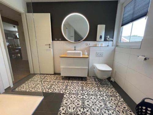 a bathroom with a sink and a mirror and a toilet at Welcome in Petersdorf auf Fehmarn