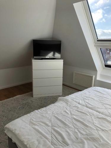 a bedroom with a bed and a tv on a dresser at Welcome in Petersdorf auf Fehmarn