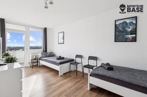Un dormitorio con dos camas y una mesa y sillas. en MONTEUR - Unterkunft für bis zu 6 Personen in 63452 Hanau - HU13, en Hanau am Main