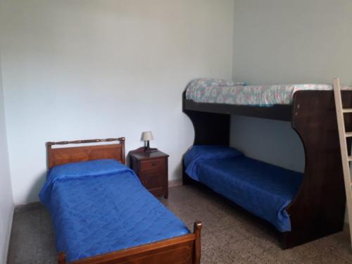 a bedroom with two beds and a bunk bed at Departamentos Tala y Tuyú in San Clemente del Tuyu