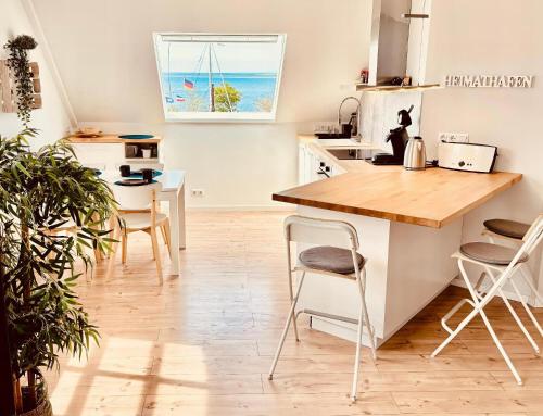 una cucina con un bancone, un tavolo e delle sedie di meerBLICK a Orth