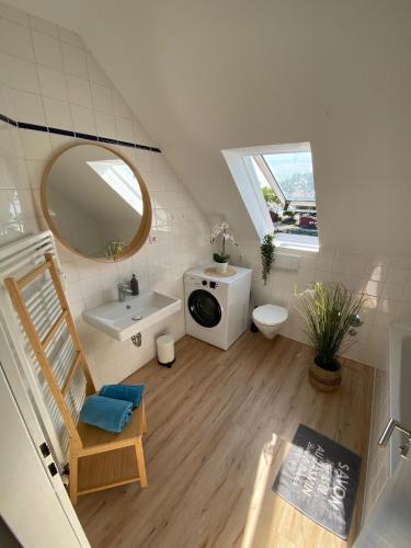 a bathroom with a sink toilet and a mirror at meerBLICK in Orth