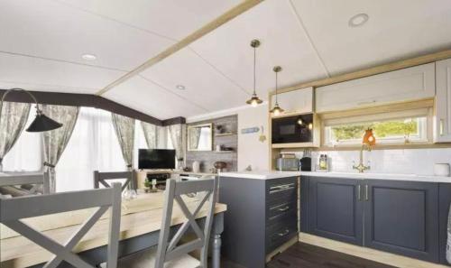 a kitchen with a table and chairs in a room at Nv48 Luxury static caravan at beautiful durdle door holiday park in West Lulworth
