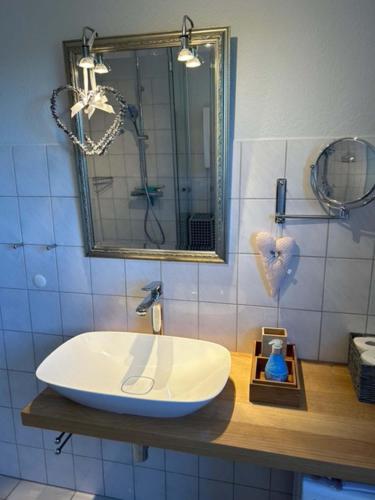 a bathroom with a white sink and a mirror at Wohnung mit Balkon und Aussicht in Petersdorf auf Fehmarn