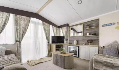 a living room with a couch and a tv at Nv48 Luxury static caravan at beautiful durdle door holiday park in West Lulworth