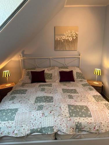 a bedroom with a bed with a quilt on it at Wohnung mit Balkon und Aussicht in Petersdorf auf Fehmarn