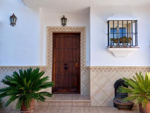 een houten deur in een gebouw met twee planten bij La Casa Del Platero in Ronda