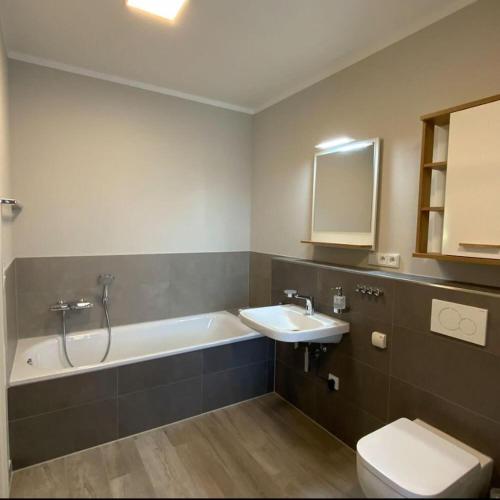 a bathroom with a tub and a sink and a toilet at Marco Polo in Petersdorf auf Fehmarn