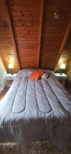 a large bed in a room with wooden ceilings at Velero de Mar in Las Grutas