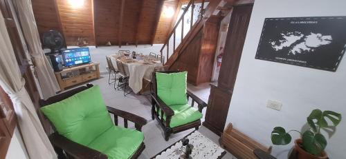 a dining room with a table and green chairs at Velero de Mar in Las Grutas