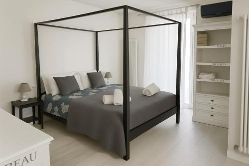 ヴィアレッジョにあるFront Beach Apartments - Deluxeのベッドルーム(天蓋付きベッド、枕付)