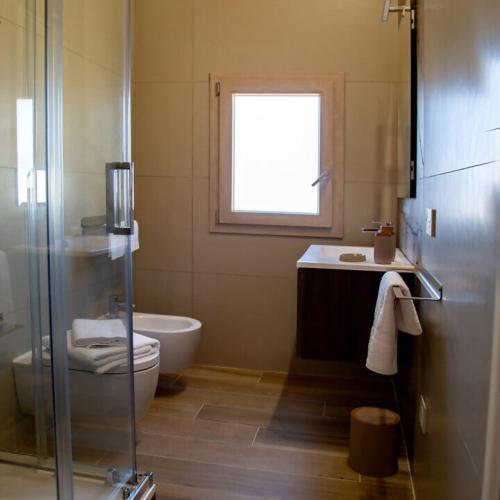 a bathroom with a shower and a toilet and a sink at Fiore dei Templi - luxury suite experience in Agrigento