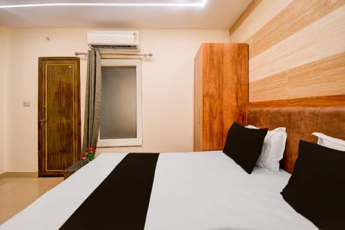 a bedroom with a large bed with a wooden headboard at Townhouse Gomti Nagar Station Formerly Budget In in Gomti Nagar