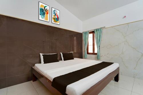 a bedroom with a large bed in a room at Collection O Perumalmalai Bus Terminal Formerly Raja Garden Hill View in Kodaikānāl