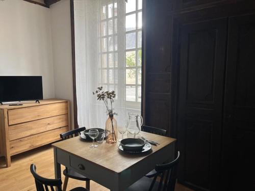 a dining room with a table and chairs and a television at T2 Centre ville - rdc in Angers