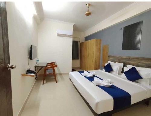 a bedroom with a large bed with blue and white pillows at Hotel O Rajahmundry Central Railway Station Formerly Sanjeevi Residency in Godāvari