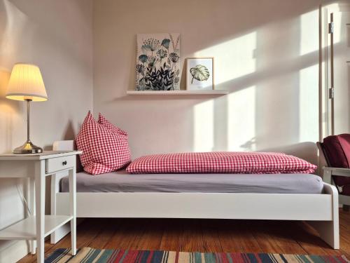a bed with red pillows on it in a room at Bahnhof Grombach in Bad Rappenau