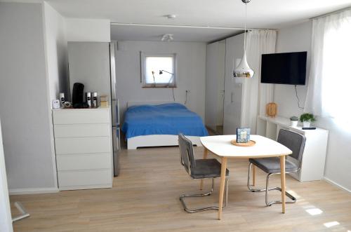 ein Schlafzimmer mit einem Bett und einem Tisch mit Stühlen in der Unterkunft Ferienwohnung Zaunkönig in Beuren